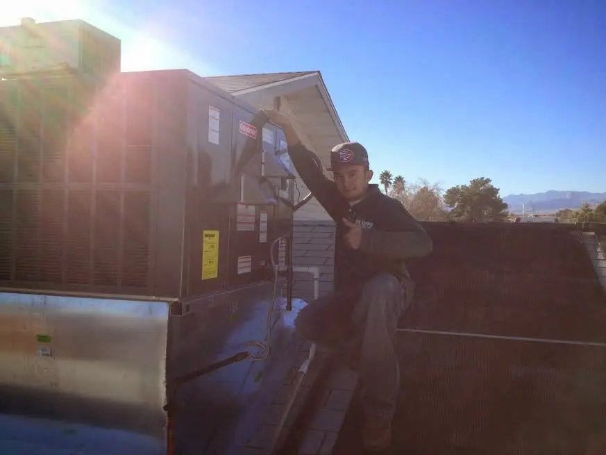 HVAC technician performing Heat Pump Repair on a rooftop unit in Cape St. Claire